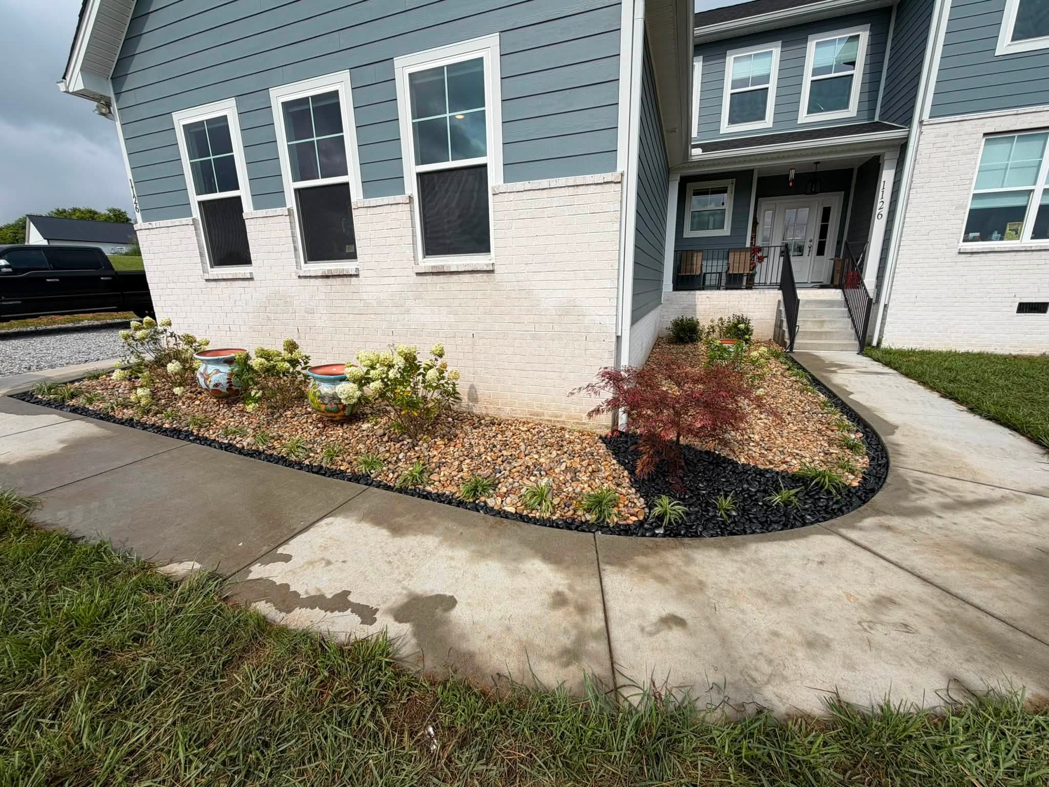 Freshly landscaped front yard with trimmed bushes and new mulch