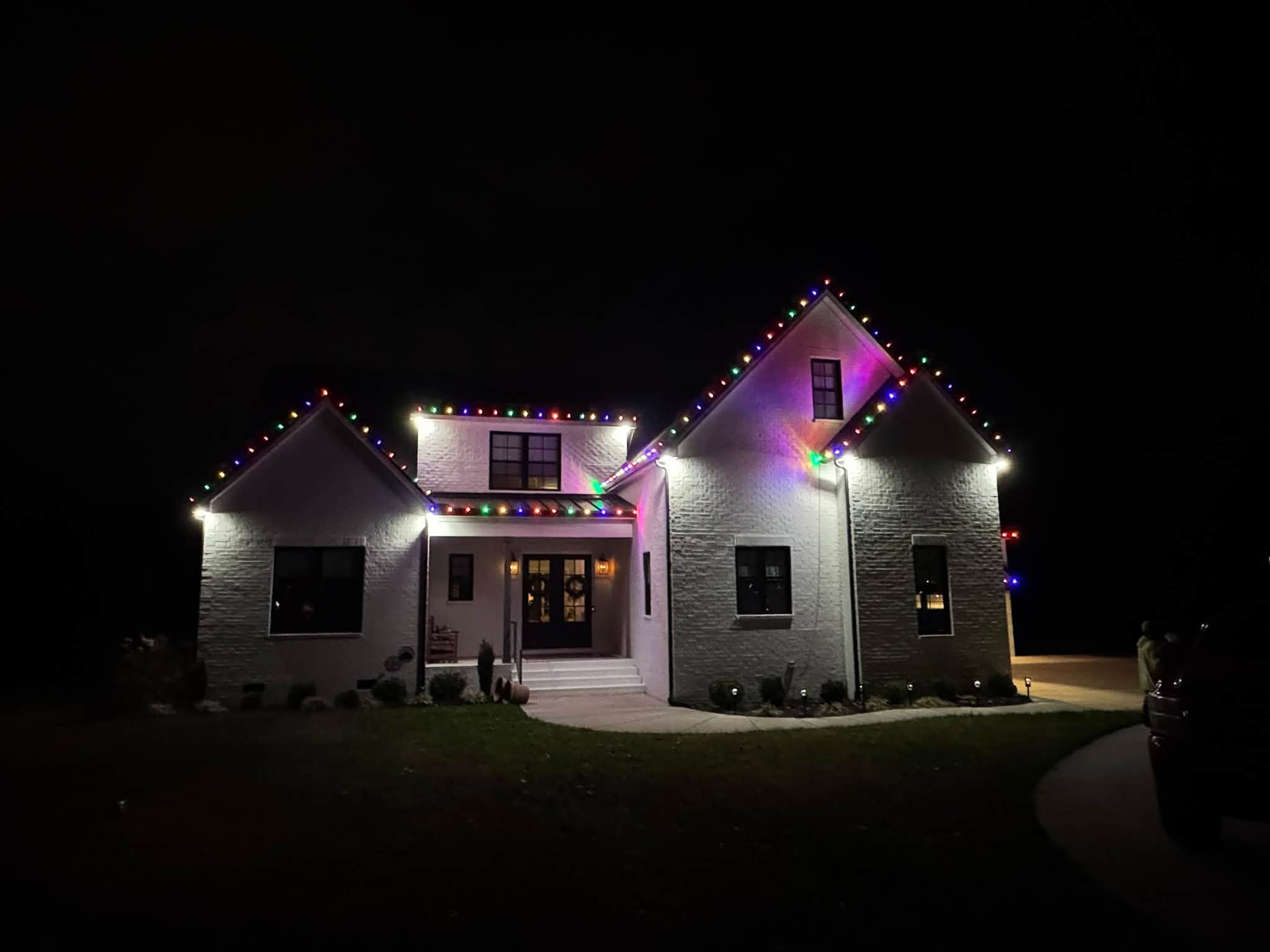 Multicolor Christmas lights on a white brick home in Sumner County